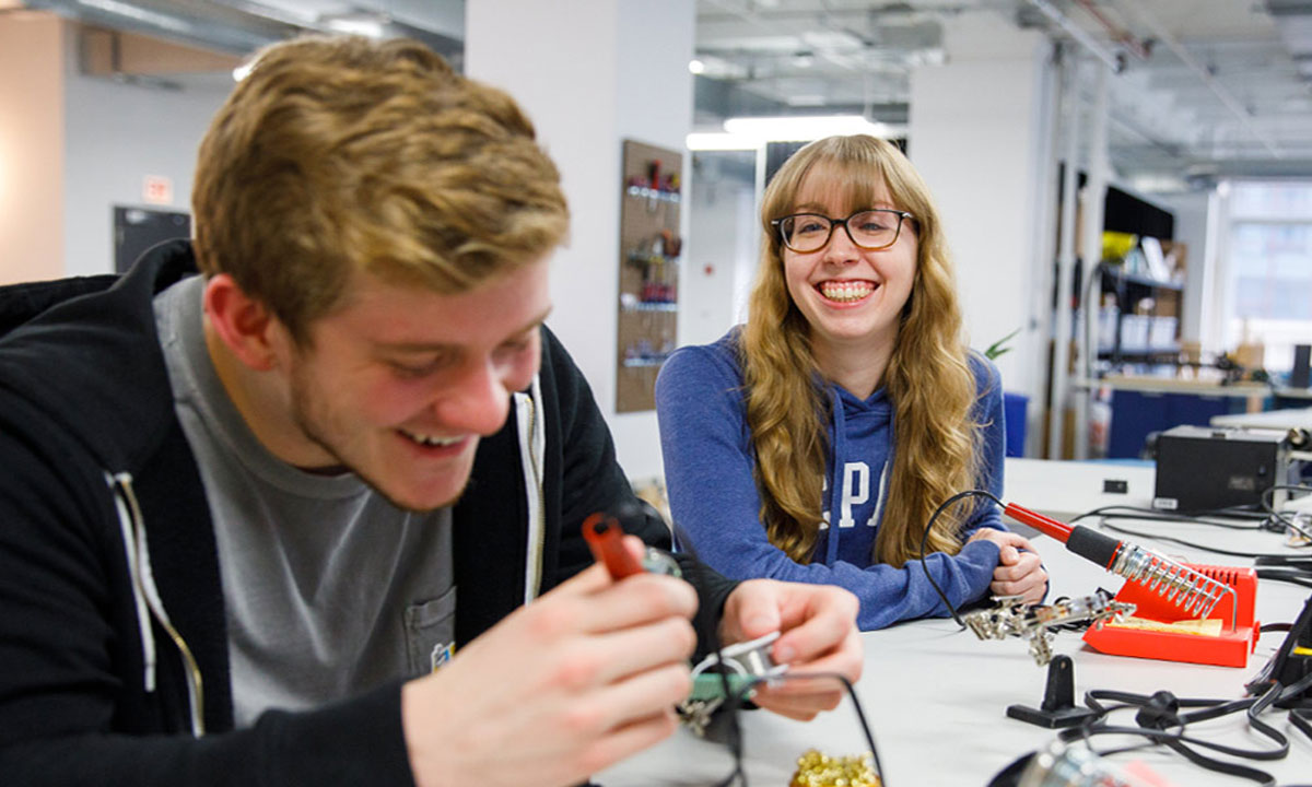2 students soldering