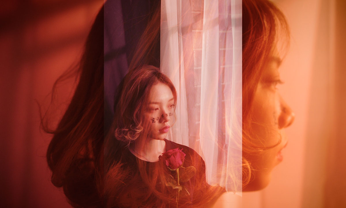 young female gazing out window